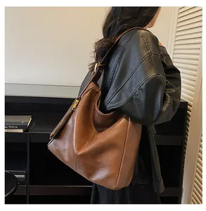 Detail view of large dark brown leather tote bag with smooth finish and side zipper detail