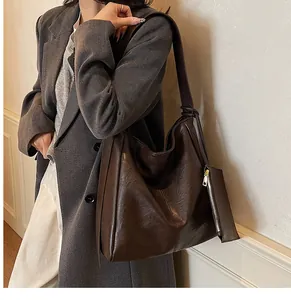 Detail of dark brown tote bag showing supple leather texture and detachable small pouch
