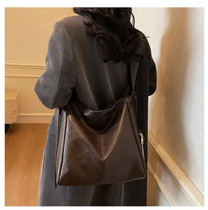Large dark brown leather tote bag shown on model for a premium commuting aesthetic