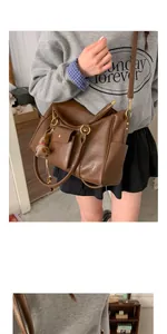 Vue détaillée du sac cabas rétro marron avec poches multiples et breloque en peluche