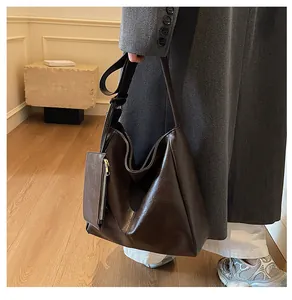 Detail of dark brown faux leather tote bag showing large capacity and small hanging pouch
