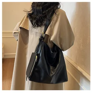 Detail of black large capacity Hobo tote bag with golden zipper and luxury leather texture