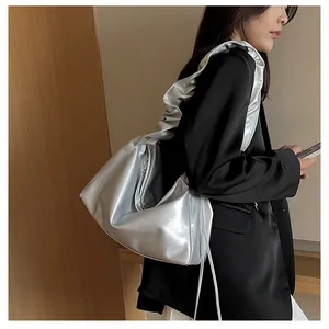 Détail d'un sac hobo argenté métallisé avec design plissé et bandoulière élégante