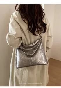 Détail du sac cabas argenté à texture froissée montrant le fini métallisé sur modèle