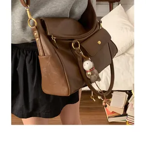 Détail du sac cabas rétro marron avec boucles en métal et charm d'âne en peluche