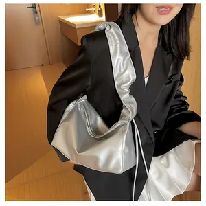 Détail du sac cabas argenté métallisé avec bandoulière plissée porté par un mannequin