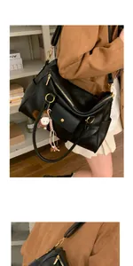 Vue latérale d'un sac cabas en cuir noir avec zip doré et un pendentif en peluche mignon