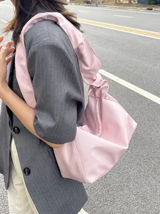 Sac fourre-tout plissé en similicuir rose clair avec large bandoulière sur costume