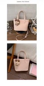Roze emmertas met litchi-textuur en een schattige pluche beer hanger aan het handvat