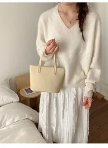 Detail van de crème tote bag met fijne litchi textuur en stevige dubbele handgrepen voor dames