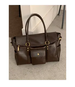 Gros plan du sac cabas vintage en cuir synthétique marron foncé avec détails dorés