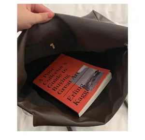 Intérieur du sac cabas marron foncé montrant le compartiment spacieux et la poche zippée
