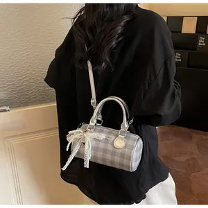 Detail of grey plaid bowling bag with white lace bow and pearl handle decoration