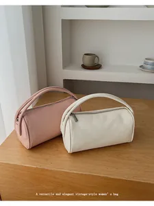 Detailansicht retro-zylindrischer Baguette-Taschen in Beige und zartrosa Kunstleder