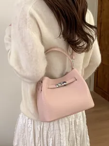 Pink lychee grain leather bucket bag with silver twist lock shown in a lifestyle setting