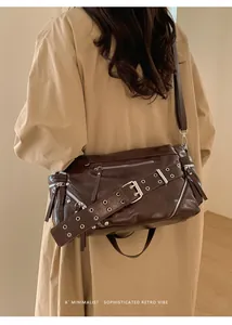 Detail showing the dark brown oil-wax leather texture and silver buckle decoration