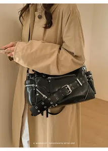 Close-up of black retro shoulder bag with silver zippers and metal rivet details