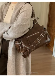Detailed close-up of dark brown retro tote bag with silver zippers and eyelets strap