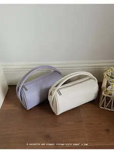 Nahaufnahme von Vintage-Zylinderhandtaschen aus Leder in Flieder und Creme mit Reißverschluss