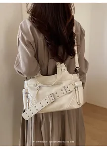Detailed view of cream retro tote bag featuring functional zippers and metallic buckles