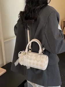 Chic beige checkered bowling bag with lace bow and pearl pendant shown on shoulder