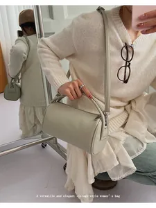 Hellgrüne zylindrische Ledertasche mit Handgriff und dünnem Schultergurt-Detail