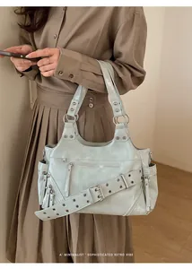 Detail of mint green tote bag with silver studs and polished PU leather texture