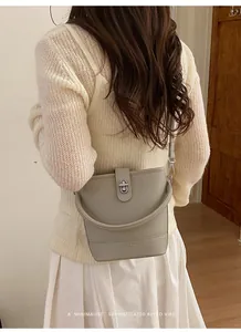 Detail view of khaki bucket bag showing lychee grain leather and metal twist lock