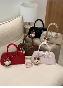 Detail of shell shoulder bags with metal horsebit hardware and plush bear charms