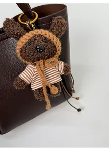 Vue détaillée d'un ours en crochet avec t-shirt rayé décorant un sac à main en cuir marron