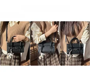 Vues détaillées d'un sac baguette noir avec anneau argenté et breloque petit cheval blanc