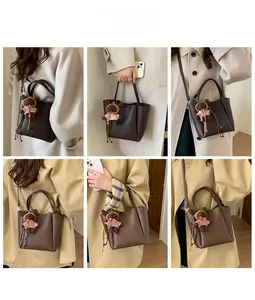 Vues détaillées d'un sac seau marron foncé avec charm ours porté par un mannequin