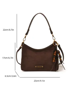 Brown faux suede dumpling bag with wooden bead tassel and dimensions on white background
