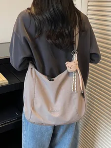 Large dark grey canvas hobo bag with teddy bear pendant and crossbody strap