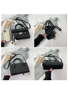 Vue détaillée du sac baguette en cuir noir mat avec boucle argentée et breloque cheval