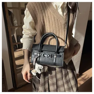 Détail du sac baguette noir avec boucle argentée et charm de petit cheval blanc