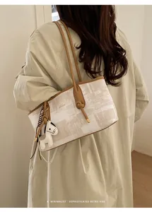 Détail d'un sac Boston beige avec charm cheval et bandoulière en cuir marron élégant