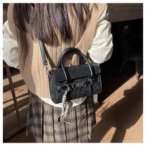 Détail de vue arrière d'un sac baguette noir avec franges et anneau métallique décoratif