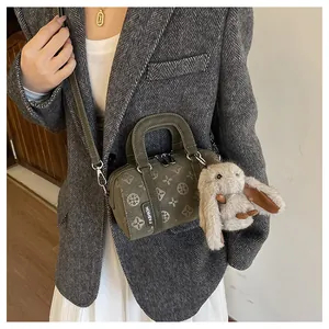Detail of dark olive green Boston bag with embossed patterns and rabbit charm