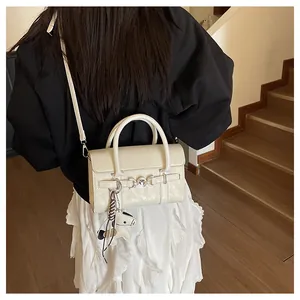 Sac baguette crème chic avec boucle chaîne argentée et breloque cheval sur mannequin
