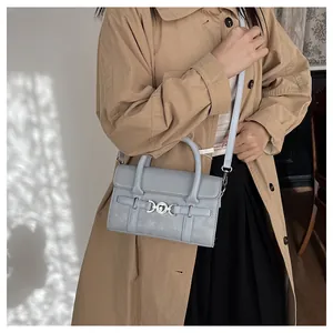Détail du sac baguette bleu clair avec boucle cœur argentée et texture cuir matelassé