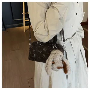 Close-up of brown textured baguette bag with a cute plush bunny charm and fashion tag