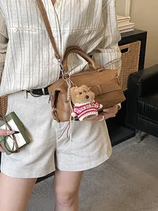 Sac Boston marron en similicuir avec boucle décorative et breloque ours en peluche