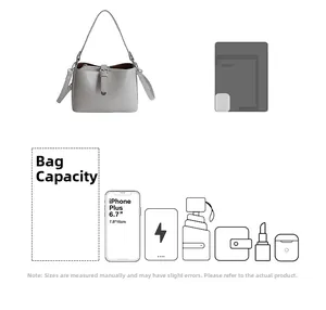 Détail de la capacité du sac gris avec téléphone, portefeuille et objets du quotidien