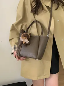 Sac seau vintage vert olive avec poignées en cuir et pendentif ours brun