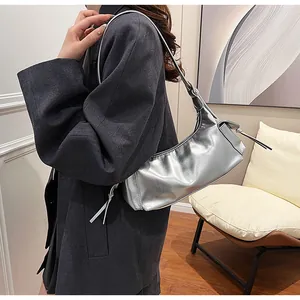 Details der silbernen Metallic-Unterachseltasche mit seitlichem Kordelzug-Dekoranhänger
