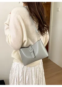 Détail du sac sous le bras minimaliste gris-vert avec boucle argentée et lanière