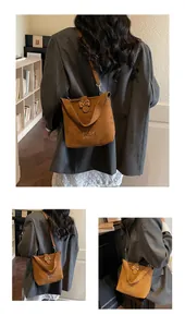 Detail of brown suede bucket bag with leopard print buckle and shoulder strap
