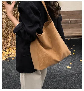 Vintage καφέ δερμάτινη τσάντα tote σε μοντέλο σε φθινοπωρινό εξωτερικό χώρο με φύλλα