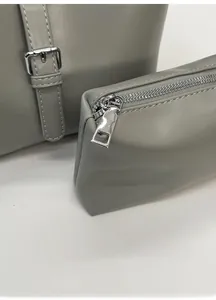Détail du sac cabas gris en cuir avec fermeture éclair et ferrures en métal argenté poli